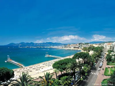 a view of a city and the ocean with palm trees at Apartment Cannes Bay-3 by Interhome in Cannes