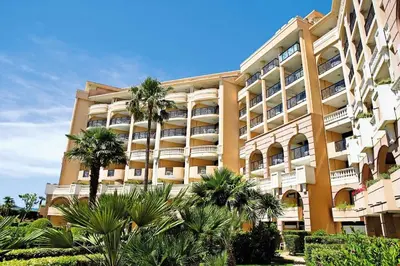 a large building with palm trees in front of it at Résidence Cannes Verrerie - maeva Home - Appartement climatisé 3 pièces 4 personnes - Budget MAE-6894 in Cannes