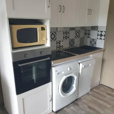 a kitchen with a microwave and a washing machine at Appartement 172 in Cannes