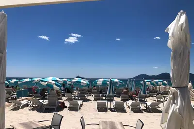 a group of chairs and umbrellas on a beach at Heart of Cannes contemporary 2BR garden view Palais & Croisette 5 mn by Olam Properties in Cannes