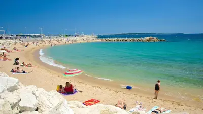 a group of people on a beach near the water at Appartement de charme proche Vieux Port et Palais in Cannes