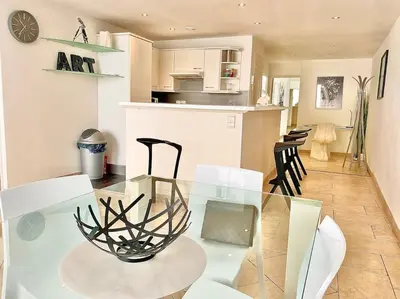 a dining room and kitchen with a glass table and chairs at Appartement Cannes 6 chambres - 8B3 in Cannes