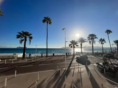 a view of a beach with palm trees and the ocean at Marjolaine luxury sea view, by Welcome to Cannes in Cannes