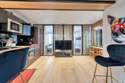 a kitchen with two blue chairs and a living room at LE NAPOLEON chic et moderne, l'endroit parfait au cœur de la Banane in Cannes