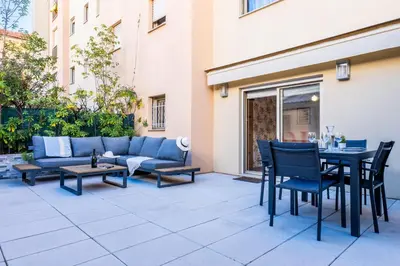 a patio with a couch and tables and chairs at RARE ! Studio with terrace 5min walk to the Palais in Cannes