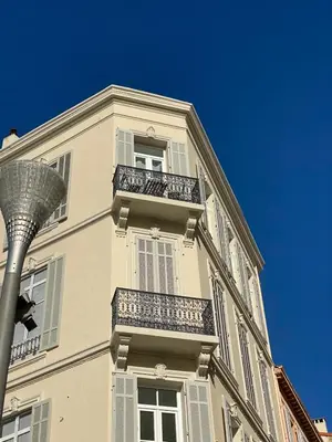 a tall white building with balconies and a street light at WELCOME - Stunning 2-bedroom at 5 minutes from Palais des Festivals in Cannes