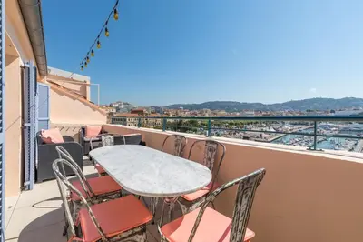 a table and chairs on a balcony with a view at Facing old Port of Cannes Duplex WOW this view Olam Properties in Cannes