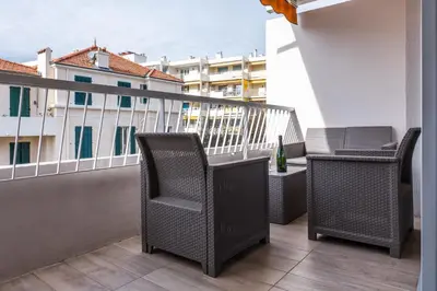 a balcony with two chairs and a bottle of wine at 2-room apartment with terrace close to the center in Cannes