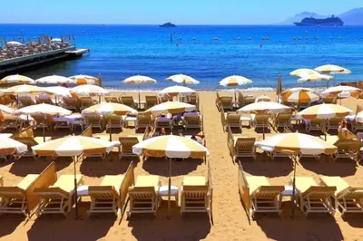 a beach with chairs and umbrellas and the ocean at 2 BR Croisette balcony & sea view Olam Properties in Cannes