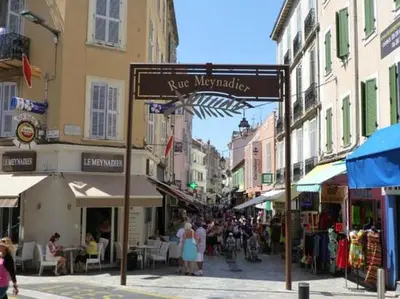 a street sign in a city with people walking down a street at 2 pièces Cannes centre in Cannes