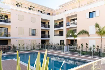 an apartment building with a swimming pool and palm trees at Modern apartment with swimming pool in Cannes