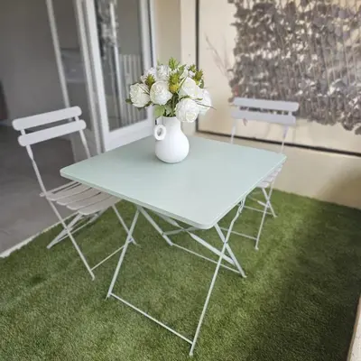 a white table with a vase with flowers on it at Studio Cannes le Val D'or Chez Lisa in Cannes