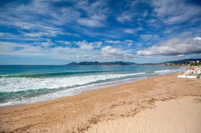 a beach with the ocean and a blue sky at Brand New Central Cannes Apt 2 min walk to Palais in Cannes