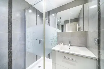 a white bathroom with a shower and a sink at Rooftop la Croisette in Cannes