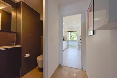 a bathroom with a toilet and a door to a hallway at 2-Br sea view private parking walk to beaches in Cannes