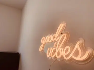 a neon sign that says good vibes on a wall at La Maison By Simone T4 in Cannes