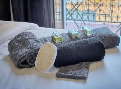 a pile of towels and candles on a bed at TOP renovated 1 bedroom near Palais 2P1 by RIVAEVENT in Cannes