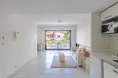 a kitchen and living room with a view of a patio at Charming apartment with balcony-pool - Cannes in Cannes