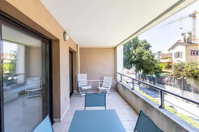a balcony with a table and chairs and a view at Charming apartment with balcony-pool - Cannes in Cannes
