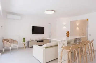 a white living room with a table and chairs at 7 Pradignac by Halldis in Cannes