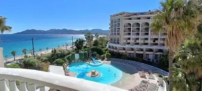 a view of the beach from the balcony of a resort at Appartement Cannes, Piscine - vue mer - terasse in Cannes