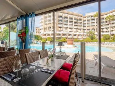 a dining room with a table and a swimming pool at ON VACAY - Votre havre de paix à 100 m des plages in Cannes