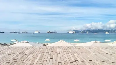 a view of a beach with boats in the water at Charmant 2 pièces, traversant, clim, wifi, parking in Cannes