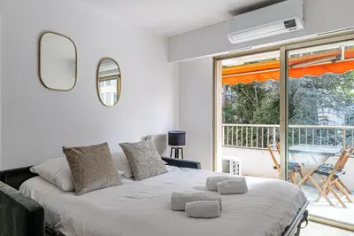 a bedroom with a large bed and a balcony at Joli 2 pcs - Prox Martinez in Cannes