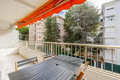a wooden table and chairs on a balcony at Joli 2 pcs - Prox Martinez in Cannes