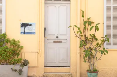 a white door on a yellow house with a plant at le suquet entre palais et des plages in Cannes