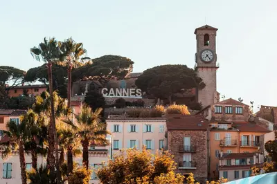 a building with a clock tower on top of a city at 4A - APARTMENT FACING PORT & Town Hall in Cannes