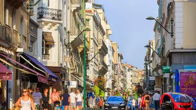 a crowd of people walking down a busy city street at Residence Aout 32 in Cannes