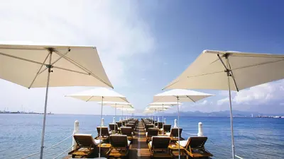 a row of chairs and white umbrellas on a pier at Residence Aout 12 in Cannes