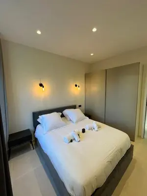 a bedroom with a large bed with two stuffed animals on it at 3 pièces en cœur de cannes in Cannes