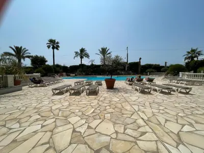 a pool with a bunch of tables and chairs at Appartement Cannes, Piscine - Terasse - 4 Personnes in Cannes