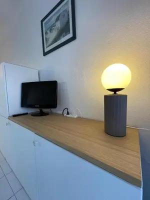 a desk with a television and a lamp on it at Appartement Cannes, Piscine - Terrasse, Jardin Privatif - 4 Personnes in Cannes