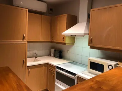 a kitchen with wooden cabinets and a white stove top oven at merimée 4G in Cannes