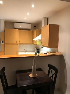 a small kitchen with a table with a vase on it at merimée 4G in Cannes