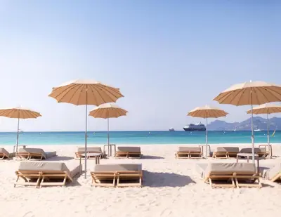 a beach with chairs and umbrellas and the ocean at Suite Palais des Festivals & Croisette 1 min in Cannes