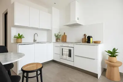 a kitchen with white cabinets and a table at French Dolce Vita near Croisette in Cannes