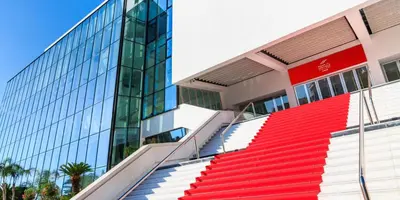 a building with red and white stairs next to a glass building at Croisette Palais des Festivals Studio in Cannes