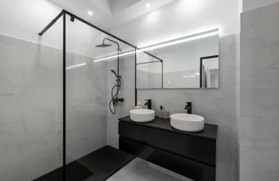 a bathroom with two sinks and a glass shower at apartment in Cannes-Croisette in Cannes