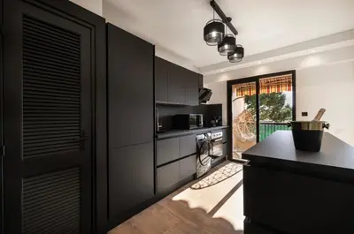 a kitchen with black cabinets and a black counter at apartment in Cannes-Croisette in Cannes