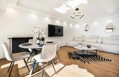 a living room with a white couch and a table and chairs at Prestigious apartment in Cannes in Cannes