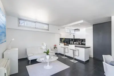 a living room with a table and a kitchen at Rooftop La Croisette Cannes in Cannes