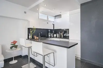 a kitchen with a black and white counter and stools at Rooftop La Croisette Cannes in Cannes