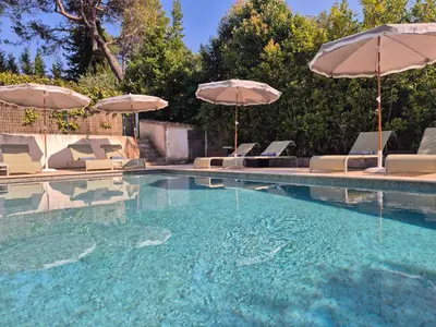 a swimming pool with chairs and umbrellas at Villa Lou San Peyre, Cannes et Mougins, 4 km des plages in Le Cannet