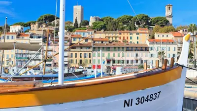 a boat docked in a harbor with buildings in the background at CG Armenonville White in Cannes