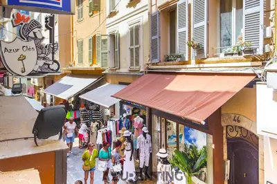 a group of people walking down a street with shops at Cozy Studio Cannes Plage Croisette 4 in Cannes
