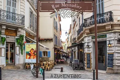 a street in a city with tables and chairs at Cozy Studio Cannes Plage Croisette 4 in Cannes